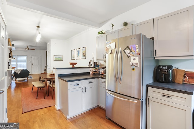 3675 Peachtree Rd NE Apt 24, Atlanta, GA 30319 - kitchen with freestanding refrigerator, a peninsula, dark countertops, a ceiling fan, and light wood-type flooring