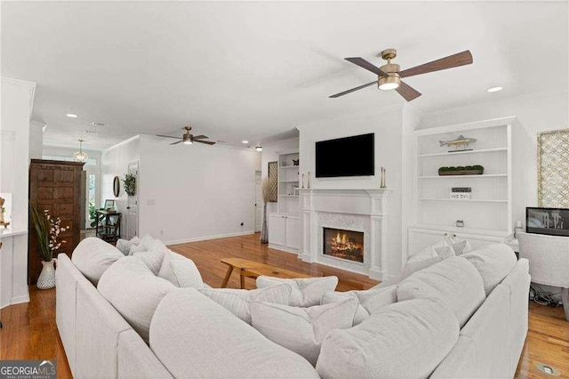 162 Drakes Lndg, Brunswick, GA 31523 - living room featuring ceiling fan, a lit fireplace, wood finished floors, recessed lighting, and built in features
