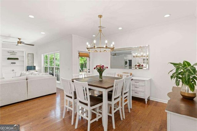 162 Drakes Lndg, Brunswick, GA 31523 - dining area with a chandelier, wood finished floors, recessed lighting, ceiling fan, and crown molding