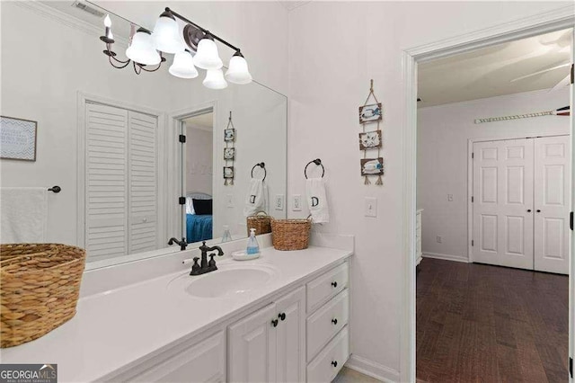 162 Drakes Lndg, Brunswick, GA 31523 - bathroom featuring vanity, a closet, ornamental molding, wood finished floors, and a chandelier