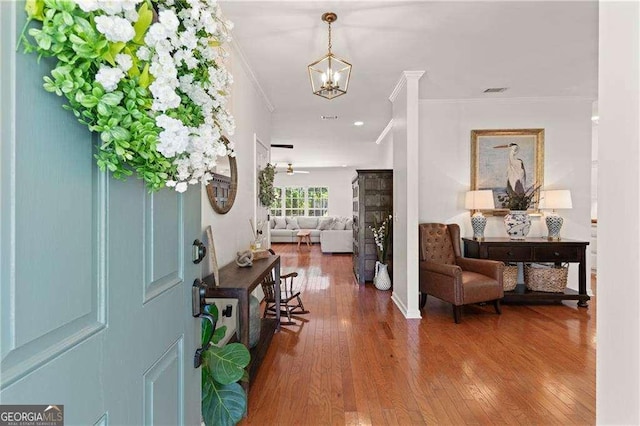 162 Drakes Lndg, Brunswick, GA 31523 - foyer entrance with ornamental molding, wood finished floors, and a chandelier