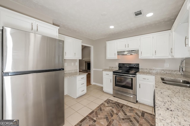 2090 Blackberry Ln, Auburn, GA 30011 - kitchen featuring appliances with stainless steel finishes, under cabinet range hood, light tile patterned floors, white cabinets, and recessed lighting