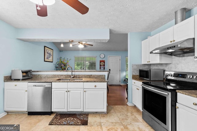 580 Lilburn School Rd, Lilburn, GA 30047 - kitchen featuring stainless steel appliances, under cabinet range hood, a ceiling fan, a peninsula, and white cabinets