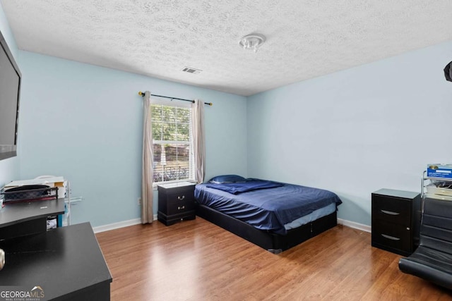 580 Lilburn School Rd, Lilburn, GA 30047 - bedroom featuring wood finished floors, a textured ceiling, and a desk