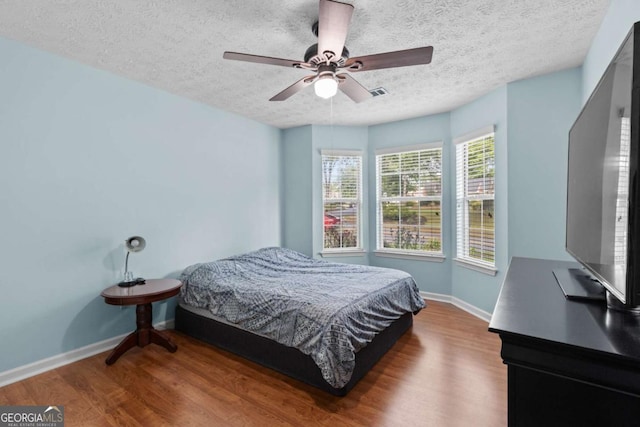 580 Lilburn School Rd, Lilburn, GA 30047 - bedroom featuring a textured ceiling, wood finished floors, and ceiling fan