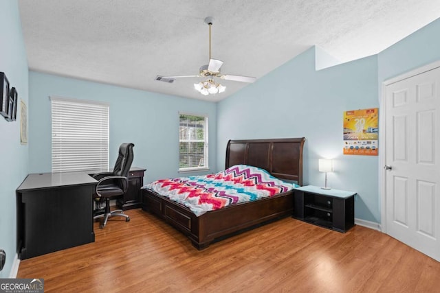 580 Lilburn School Rd, Lilburn, GA 30047 - bedroom featuring light wood finished floors, an office area, a textured ceiling, and a ceiling fan