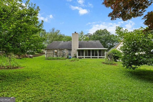 580 Lilburn School Rd, Lilburn, GA 30047 - back of house with a sunroom, a yard, and a chimney