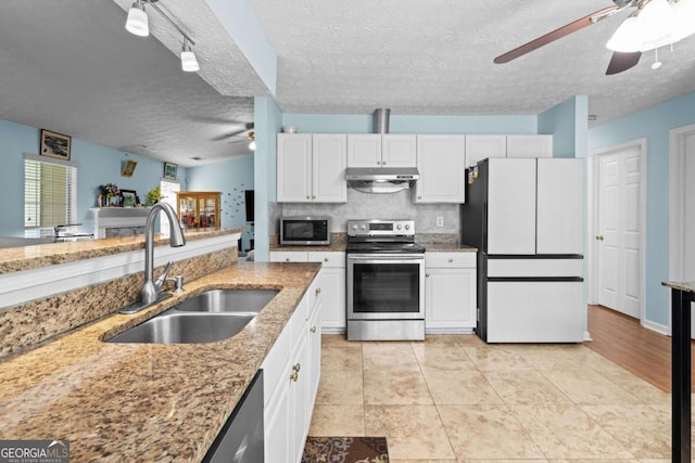 580 Lilburn School Rd, Lilburn, GA 30047 - kitchen featuring stainless steel appliances, a ceiling fan, under cabinet range hood, white cabinetry, and a textured ceiling