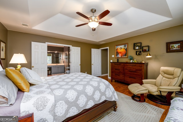1767 Tidewell Trce, Lawrenceville, GA 30043 - bedroom featuring a raised ceiling, dark wood finished floors, ensuite bath, and ceiling fan