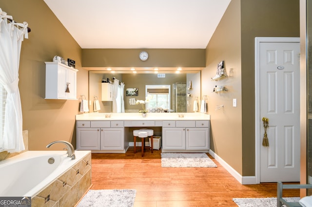1767 Tidewell Trce, Lawrenceville, GA 30043 - full bathroom featuring double vanity, a bath, wood finished floors, and a shower