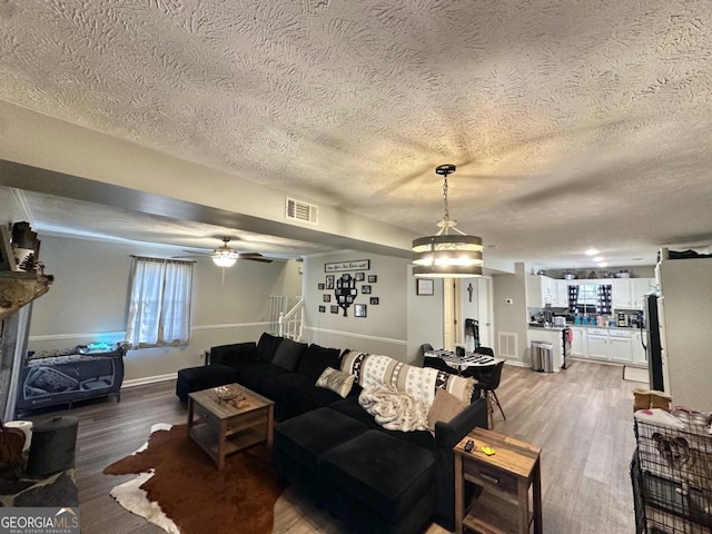 317 Running Deer Rd, Cleveland, GA 30528 - living room with a textured ceiling, wood finished floors, stairway, and ceiling fan