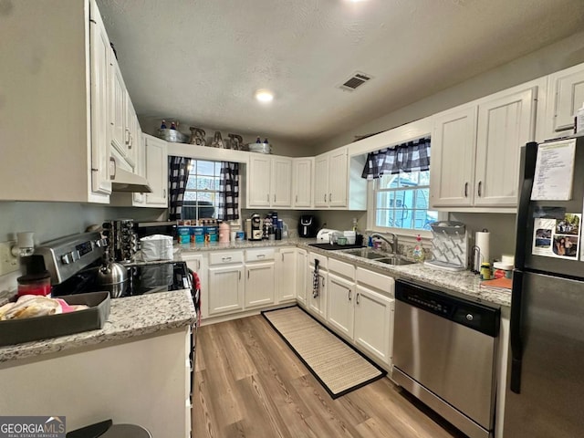 317 Running Deer Rd, Cleveland, GA 30528 - kitchen with stainless steel appliances, white cabinets, light wood-type flooring, and light stone counters