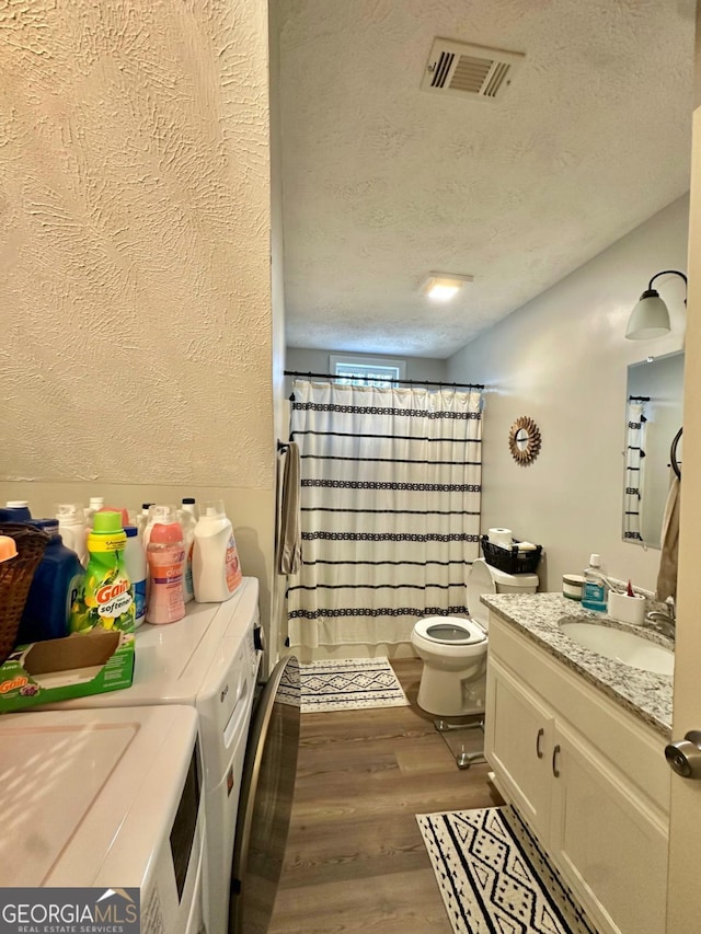 317 Running Deer Rd, Cleveland, GA 30528 - full bathroom with independent washer and dryer, vanity, wood finished floors, a textured ceiling, and curtained shower