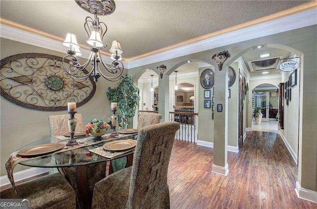 186 Wolverine Dr, Waleska, GA 30183 - dining space with arched walkways, ornamental molding, a chandelier, wood finished floors, and a textured ceiling