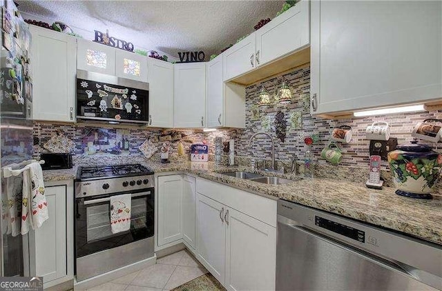 186 Wolverine Dr, Waleska, GA 30183 - kitchen with stainless steel appliances, backsplash, white cabinets, light stone counters, and a textured ceiling