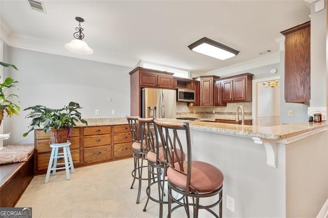 1979 Spivey Vlg, Jonesboro, GA 30236 - kitchen featuring appliances with stainless steel finishes, crown molding, a kitchen breakfast bar, tasteful backsplash, and light stone counters