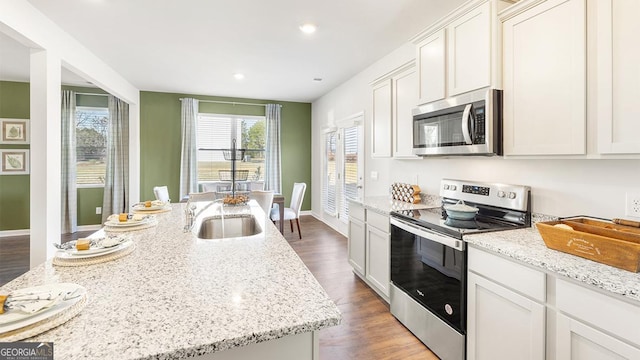 11893 Aukerman Way, Hampton, GA 30228 - kitchen with appliances with stainless steel finishes, wood finished floors, light stone counters, recessed lighting, and white cabinets