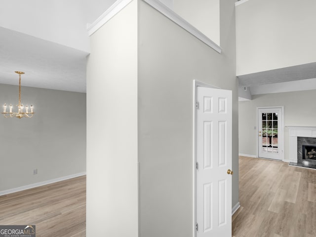 404 Northwind Pl, Stockbridge, GA 30281 - hall with light wood-style flooring, a chandelier, and a towering ceiling