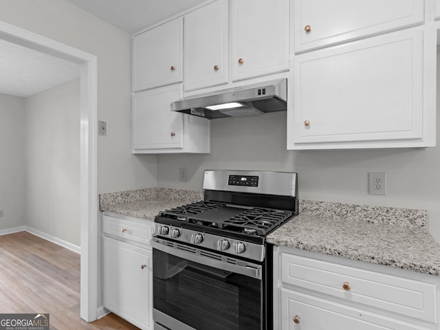 404 Northwind Pl, Stockbridge, GA 30281 - kitchen featuring stainless steel gas stove, under cabinet range hood, white cabinets, light wood-type flooring, and light stone countertops