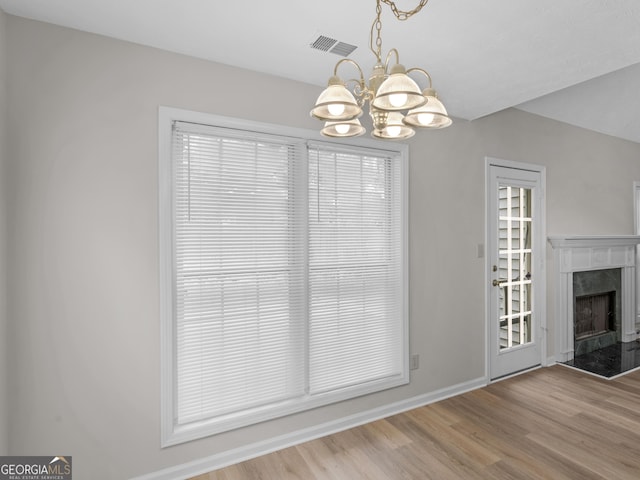 404 Northwind Pl, Stockbridge, GA 30281 - unfurnished living room with a chandelier, wood finished floors, and a high end fireplace