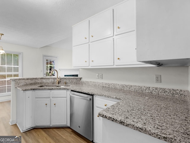 404 Northwind Pl, Stockbridge, GA 30281 - kitchen featuring dishwasher, a peninsula, light wood-style flooring, and white cabinetry