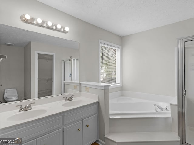 404 Northwind Pl, Stockbridge, GA 30281 - bathroom with a shower stall, a textured ceiling, a garden tub, double vanity, and a walk in closet