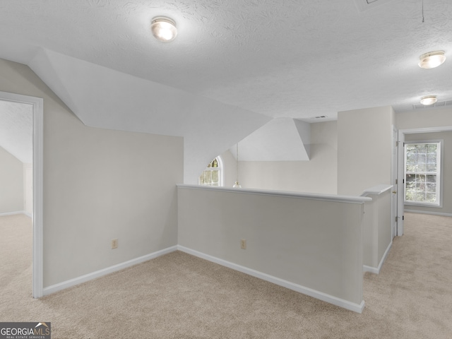 404 Northwind Pl, Stockbridge, GA 30281 - additional living space with carpet, lofted ceiling, and a textured ceiling