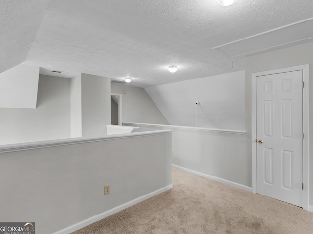 404 Northwind Pl, Stockbridge, GA 30281 - bonus room featuring attic access, a textured ceiling, carpet floors, and lofted ceiling