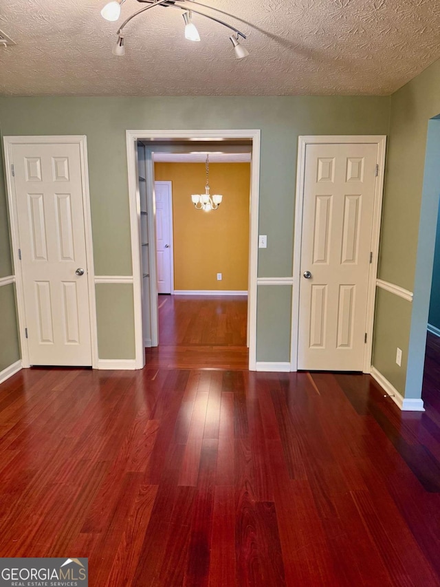 1013 Navaho Trl, Monroe, GA 30655 - empty room with a chandelier, wood finished floors, and a textured ceiling