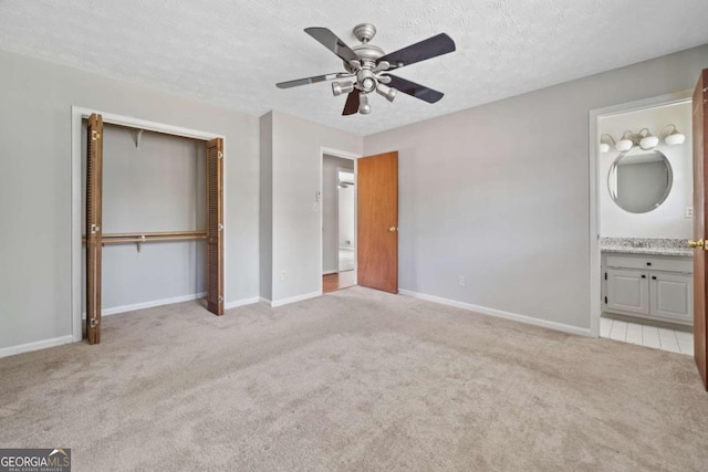 58 6th Ave W, Dallas, GA 30157 - unfurnished bedroom with carpet, a closet, a textured ceiling, ceiling fan, and ensuite bath