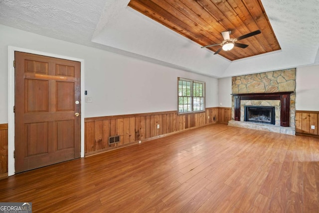 58 6th Ave W, Dallas, GA 30157 - unfurnished living room featuring wood finished floors, a wainscoted wall, ceiling fan, a raised ceiling, and wooden walls