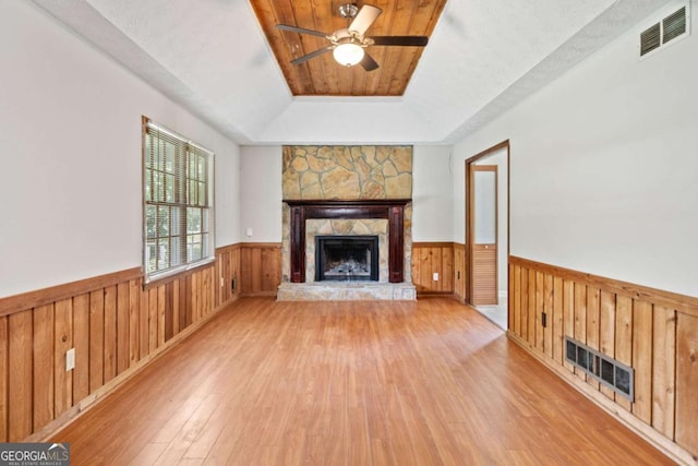 58 6th Ave W, Dallas, GA 30157 - unfurnished living room with a stone fireplace, hardwood / wood-style flooring, ceiling fan, a wainscoted wall, and a tray ceiling