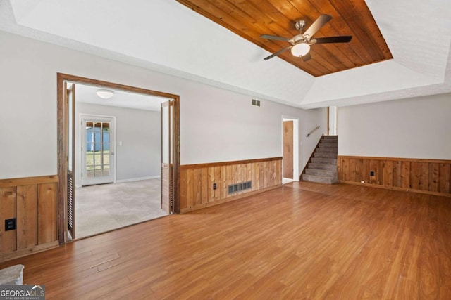 58 6th Ave W, Dallas, GA 30157 - unfurnished living room featuring wainscoting, wood walls, wood finished floors, a raised ceiling, and ceiling fan