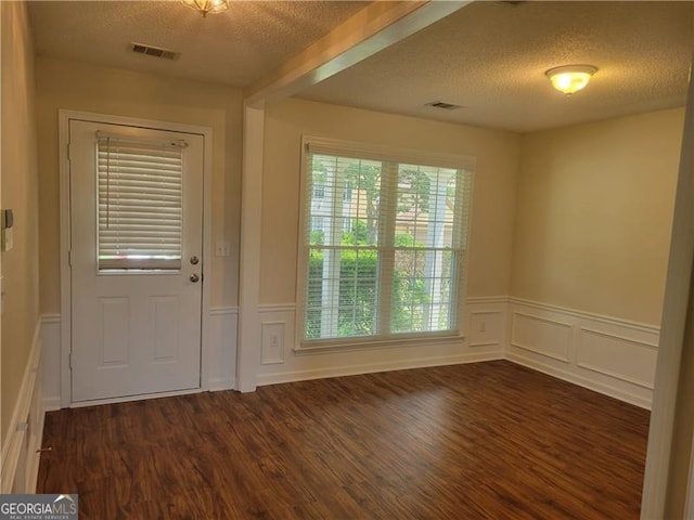13565 Weycroft Cir, Alpharetta, GA 30004 - foyer with a textured ceiling, dark wood-style flooring, a decorative wall, and a wainscoted wall