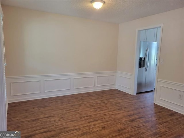 13565 Weycroft Cir, Alpharetta, GA 30004 - unfurnished room featuring dark wood-style floors, a wainscoted wall, and a decorative wall
