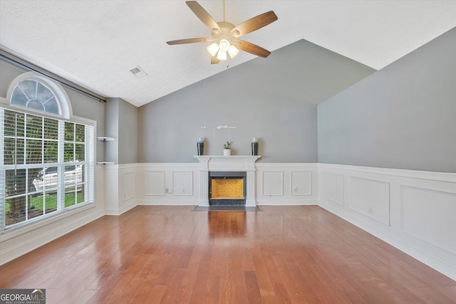 375 Shadetree Ln, Lawrenceville, GA 30044 - unfurnished living room featuring wainscoting, hardwood / wood-style flooring, a fireplace with flush hearth, ceiling fan, and vaulted ceiling