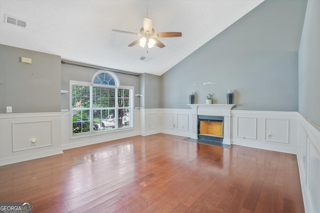 375 Shadetree Ln, Lawrenceville, GA 30044 - unfurnished living room with a wainscoted wall, ceiling fan, a decorative wall, a fireplace with flush hearth, and lofted ceiling