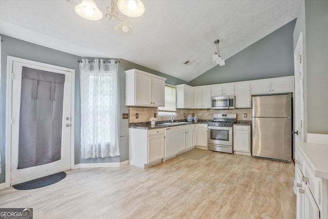 375 Shadetree Ln, Lawrenceville, GA 30044 - kitchen with appliances with stainless steel finishes, a chandelier, decorative backsplash, vaulted ceiling, and white cabinets