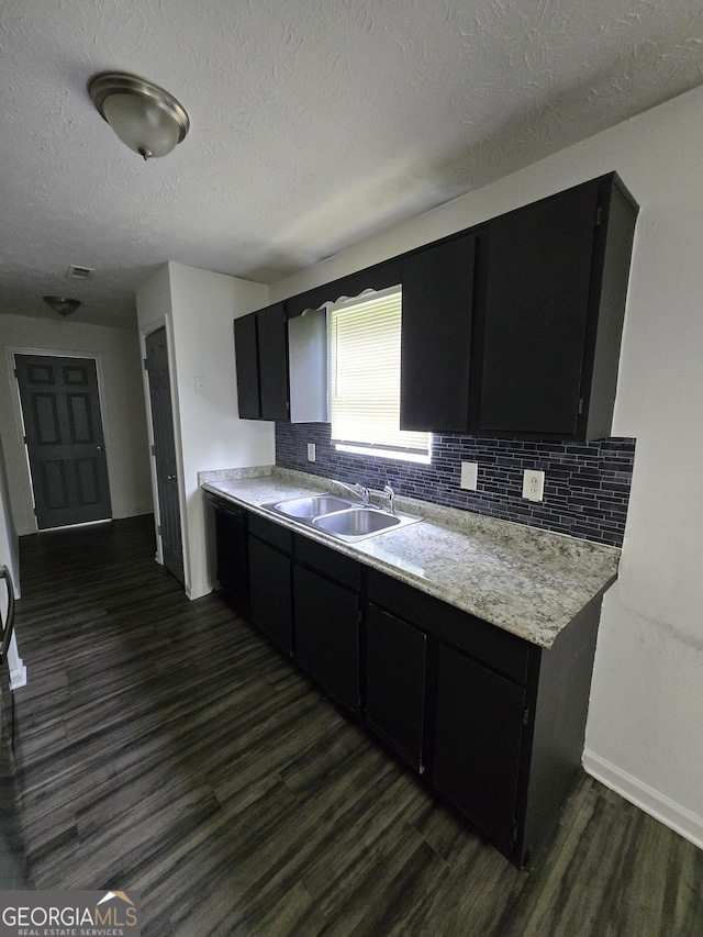 2985 Garnet Way S, Fulton, GA 30349 - kitchen featuring dark cabinets, dark wood-style flooring, a textured ceiling, light countertops, and tasteful backsplash
