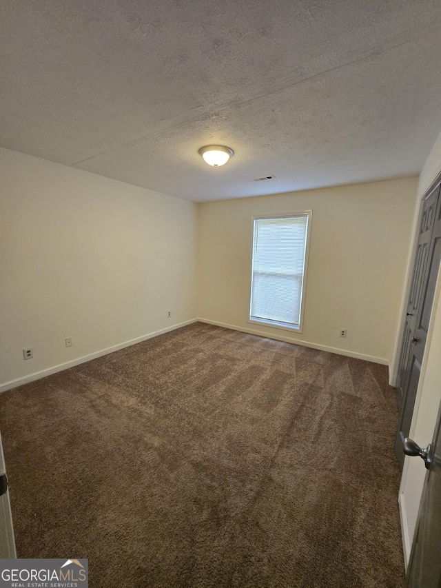 2985 Garnet Way S, Fulton, GA 30349 - empty room featuring dark carpet and a textured ceiling
