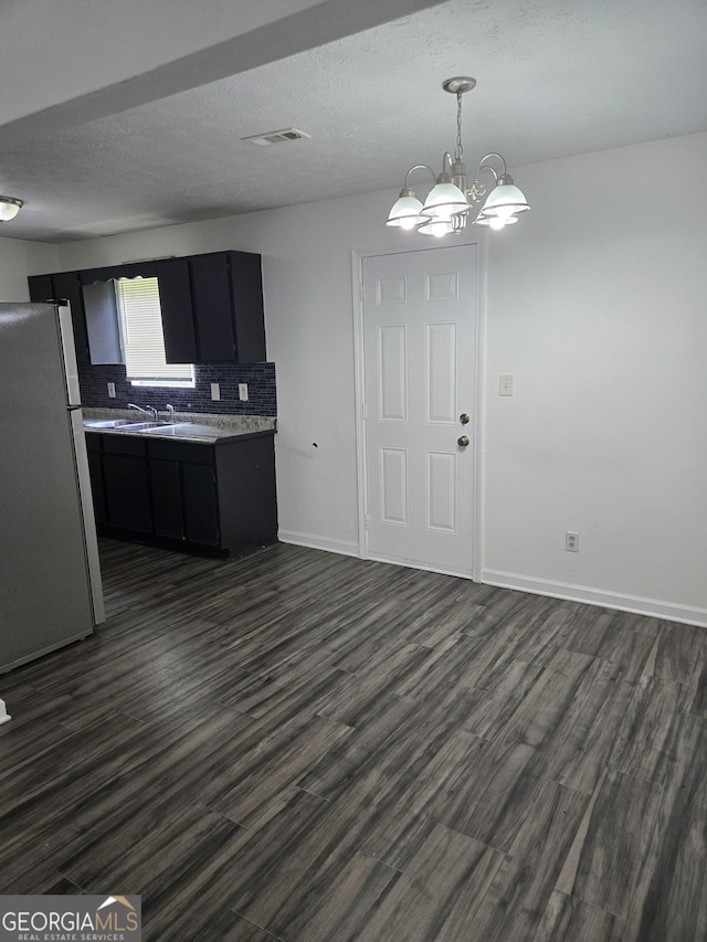 2985 Garnet Way S, Fulton, GA 30349 - kitchen featuring freestanding refrigerator, dark cabinetry, dark wood-type flooring, light countertops, and a textured ceiling