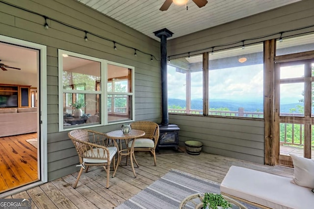 990 Hickory Nut Mountain Rd, Tallulah Falls, GA 30573 - sunroom / solarium with a ceiling fan, a wood stove, and rail lighting