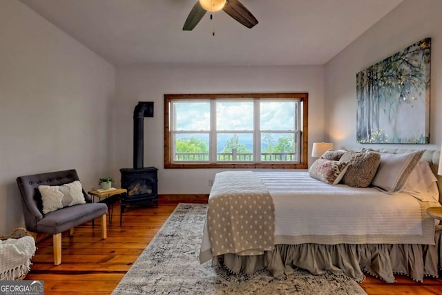 990 Hickory Nut Mountain Rd, Tallulah Falls, GA 30573 - bedroom with a wood stove, wood finished floors, and a ceiling fan