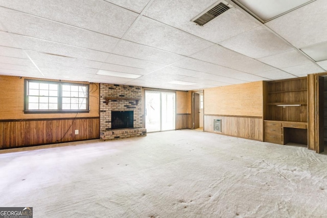 4714 Darlene Way, Tucker, GA 30084 - unfurnished living room with wood walls, plenty of natural light, built in shelves, a brick fireplace, and a drop ceiling