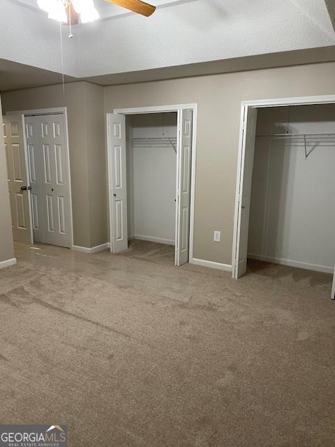 207 Oak Cir N, Stockbridge, GA 30281 - unfurnished bedroom with two closets, carpet, and ceiling fan