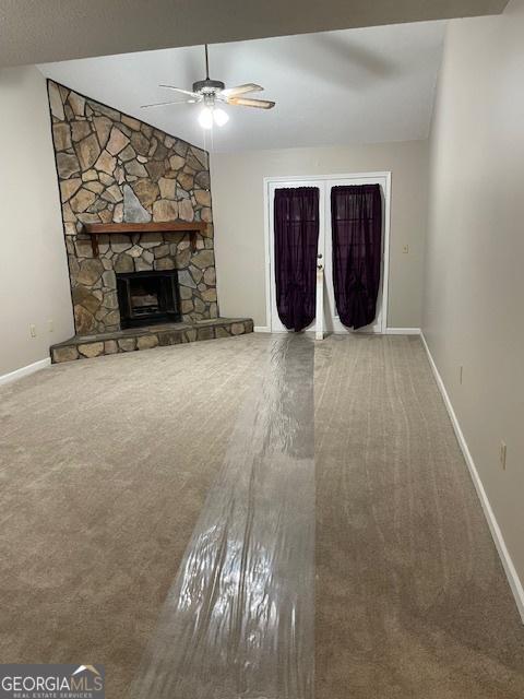 207 Oak Cir N, Stockbridge, GA 30281 - unfurnished living room with a ceiling fan, carpet flooring, and a fireplace