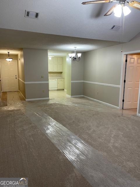 207 Oak Cir N, Stockbridge, GA 30281 - unfurnished living room featuring a chandelier and a ceiling fan