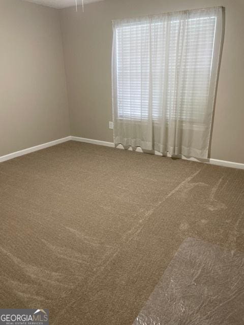 207 Oak Cir N, Stockbridge, GA 30281 - carpeted spare room featuring baseboards