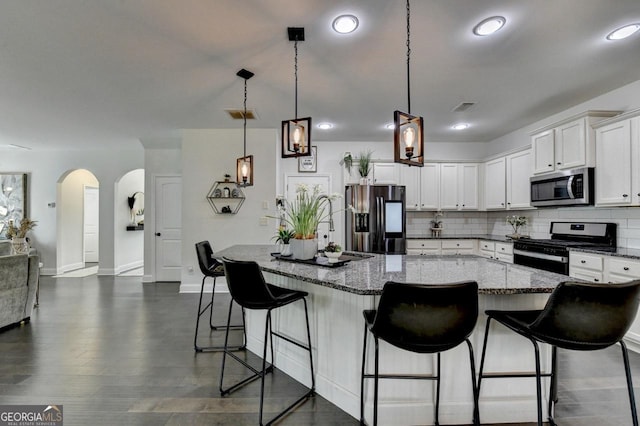 2410 Melton Common Dr, Dacula, GA 30019 - kitchen featuring stainless steel appliances, arched walkways, decorative backsplash, white cabinets, and recessed lighting