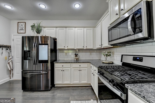 2410 Melton Common Dr, Dacula, GA 30019 - kitchen with stainless steel appliances, dark stone counters, tasteful backsplash, white cabinetry, and recessed lighting